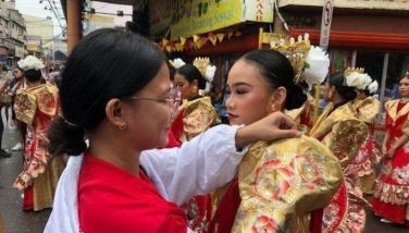 A props girl from the contingent of Carcar City fixes and retouches the costumes of the dancers before the parade for the One Cebu Island Sinulog sa Kabataan on January 8, 2023. 